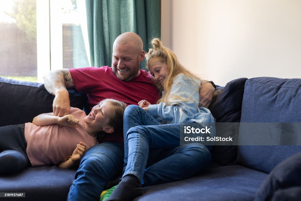 Dad with daughters, laughing, home